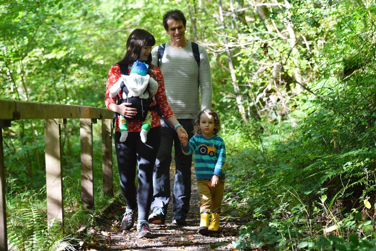 Young family walking in the woods.