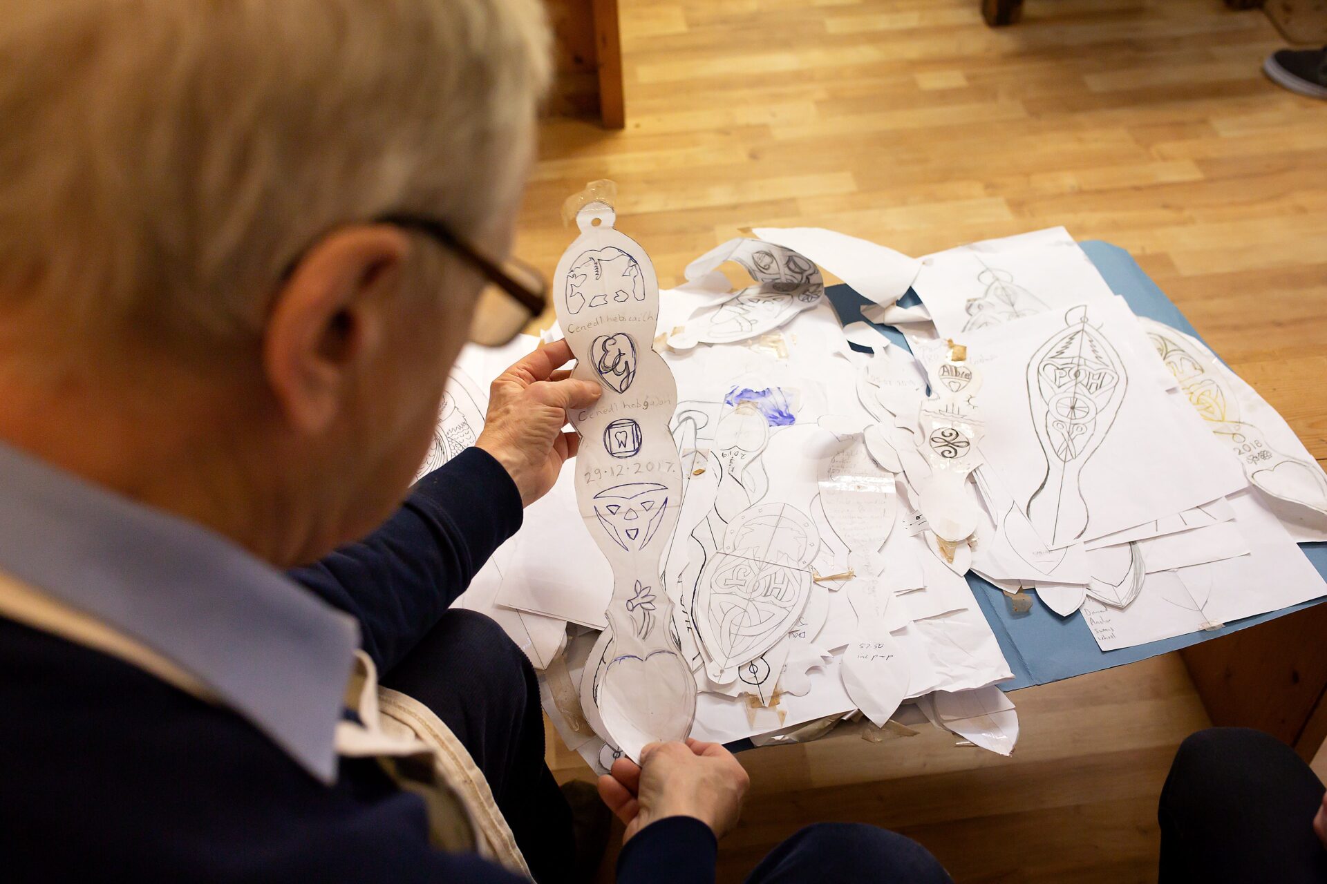 Person doing arts and crafts on a wooden table