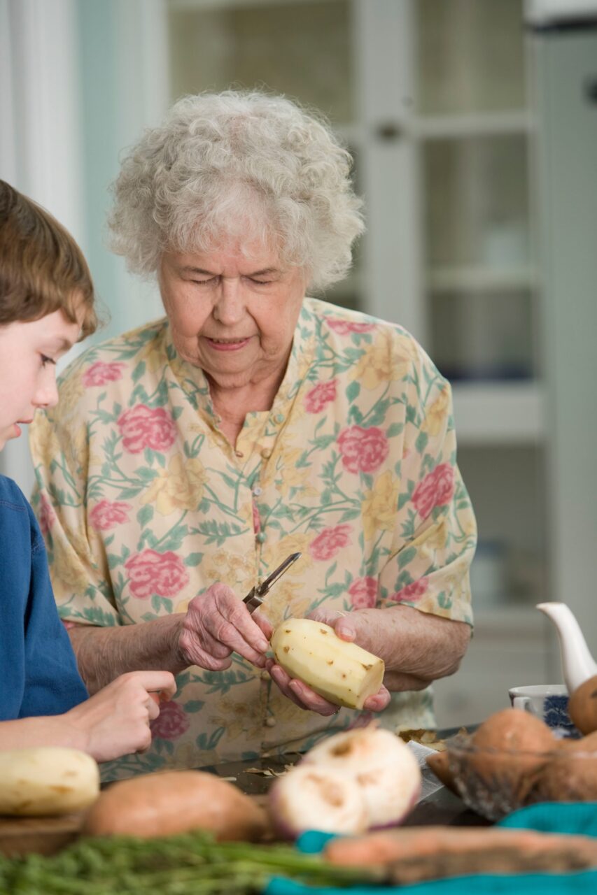 Person peeling potatoes with a child