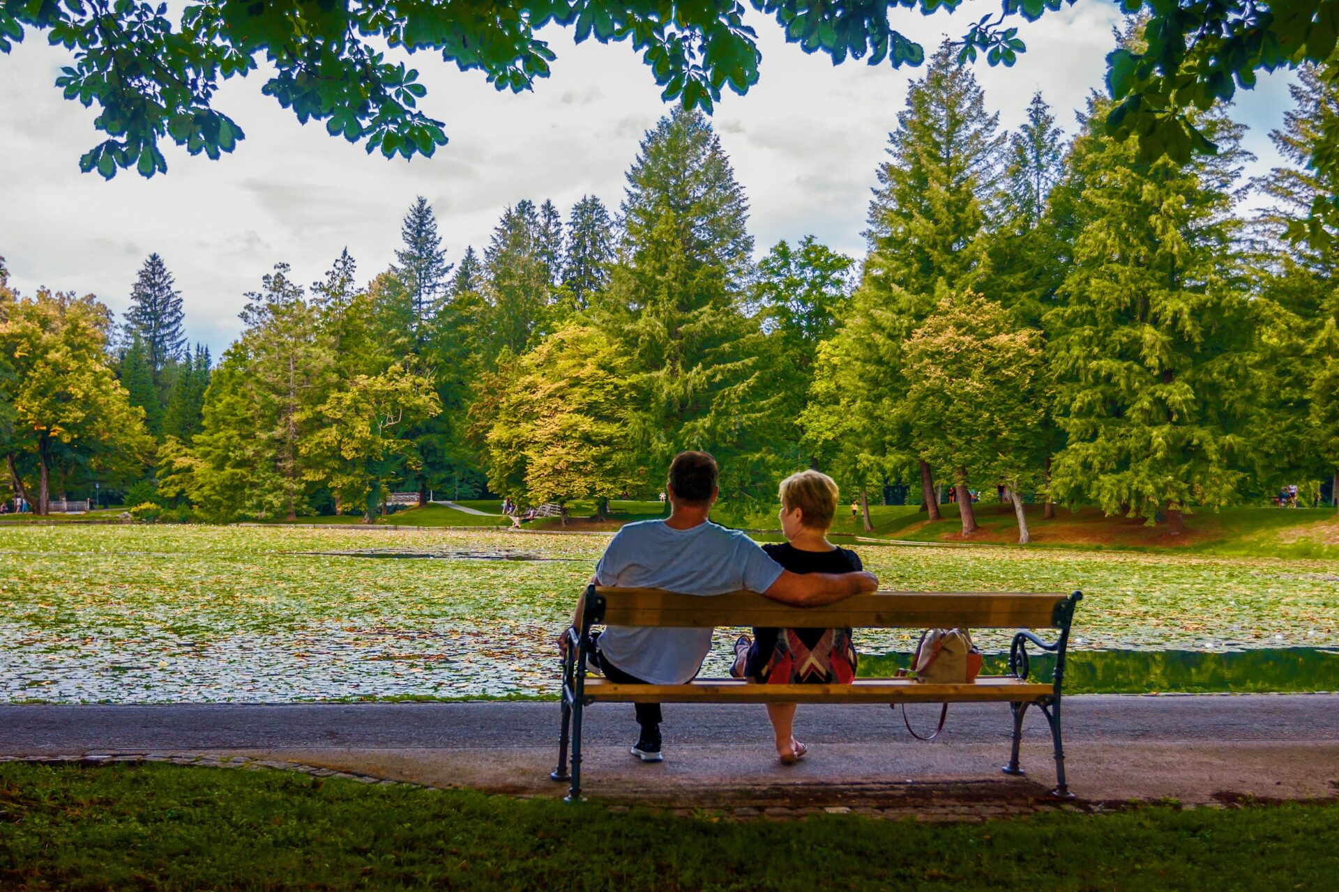 Two people sitting on a bench in a park