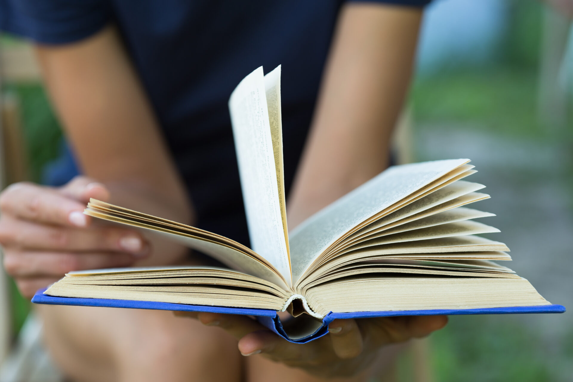 Woman flicking through the pages of an old book.