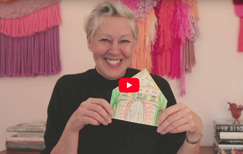 A still image taken from ‘Moments of fun and wonder’ showing Emma Jones smiling and holding a craft project they’ve completed