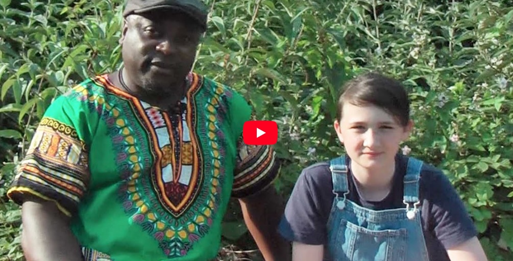 A still image taken from the ‘visceral storytelling - Poetry, songs and storytelling’ video showing a man sitting next to a young person.