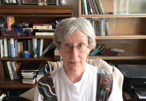 Gwyneth Lewis sitting in front of a bookcase.