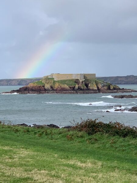 A rainbow above a small island in the sea