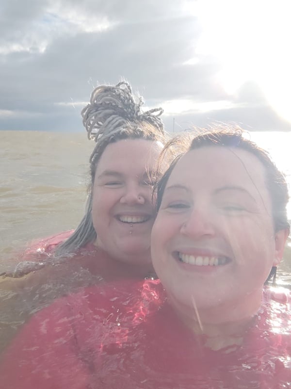 A selfie of two women smiling while in the sea