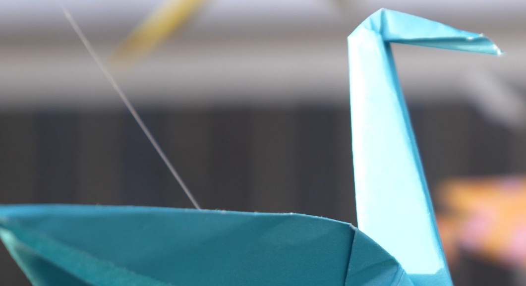 Close up of a crane fashioned out of blue construction paper.