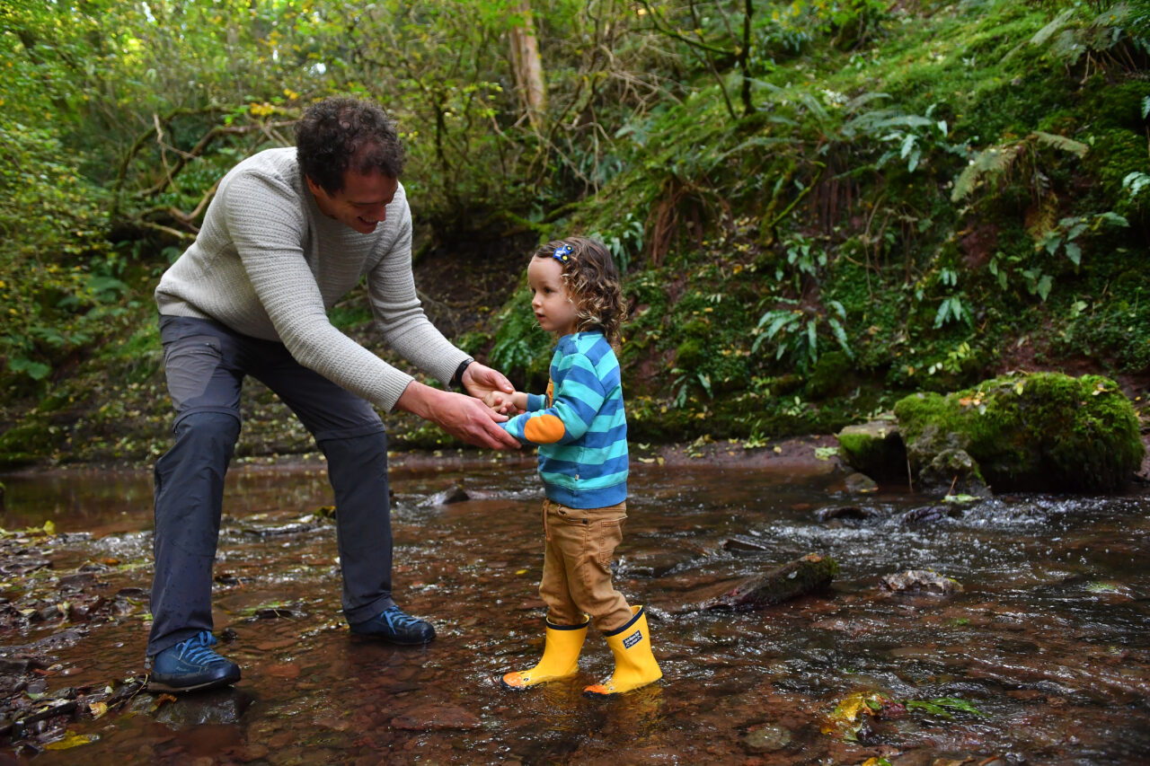 Man and child walking in woods