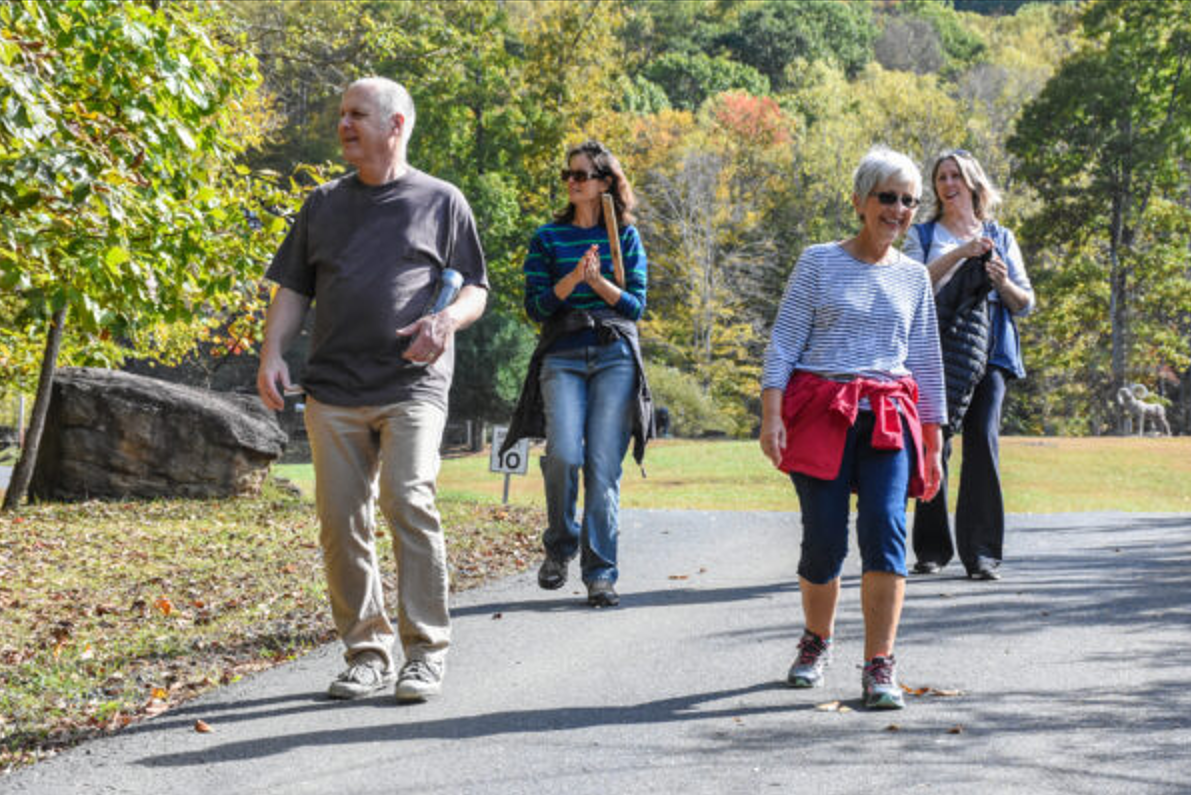 4 adults walking down a road