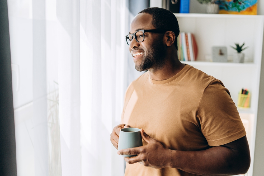 Picture of smiling young man, relaxing at home