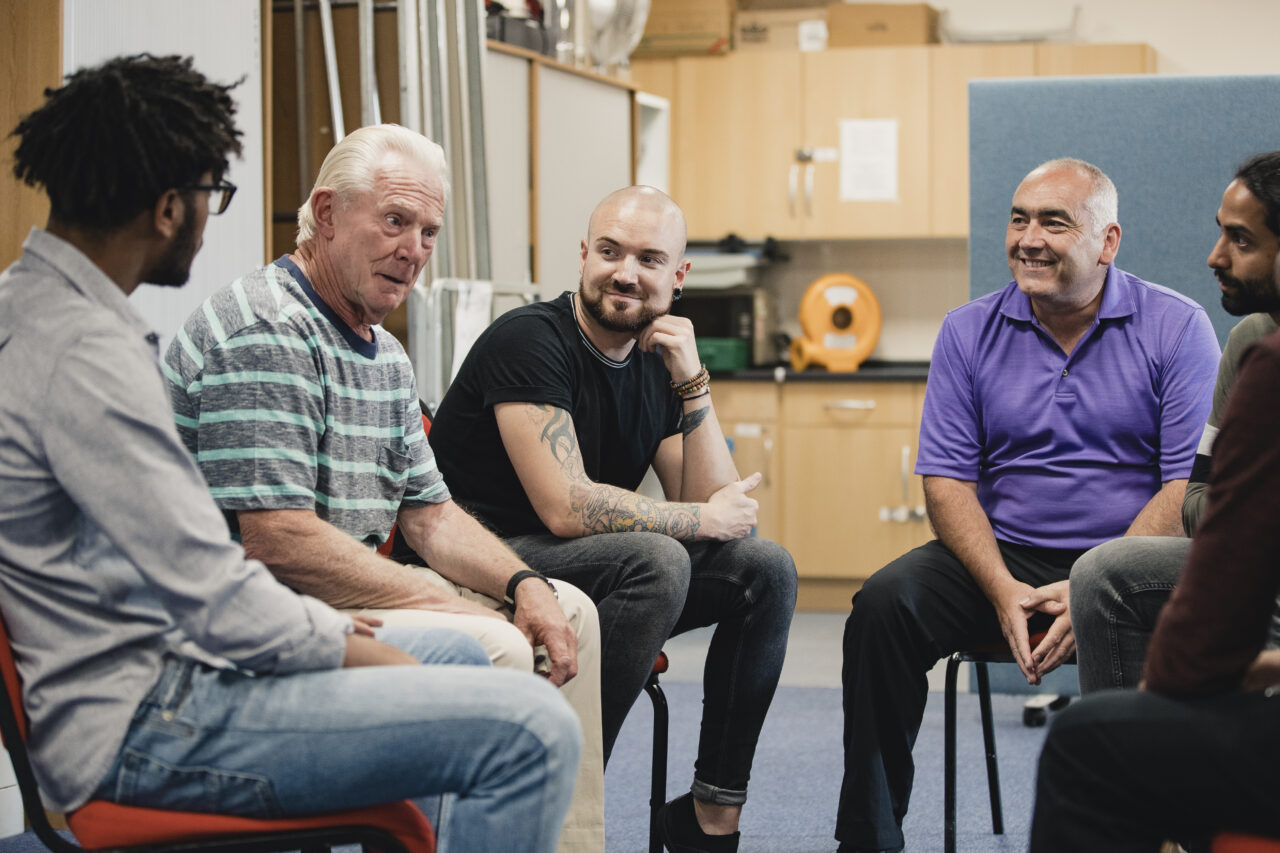A group of men sitting in a group to talk to each other